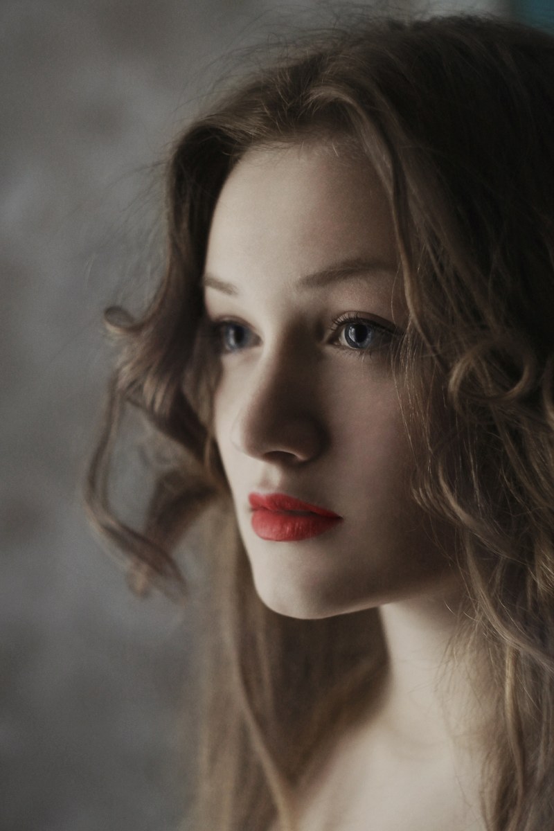 woman with soft curls and subtle makeup looking into the distance, soft curls 4k