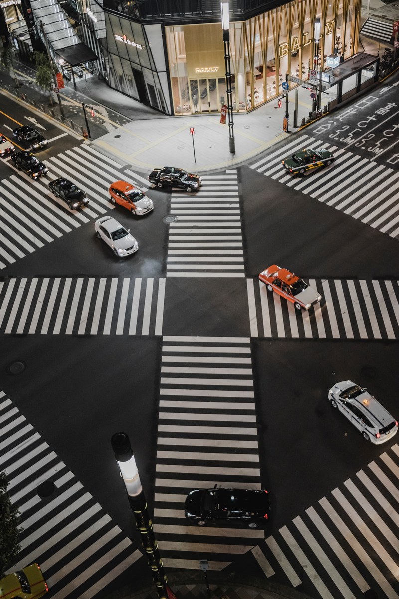 illuminated traffic intersection in ginza with crosswalks going in many directions and cars driving past, japan pt_ 2 4k