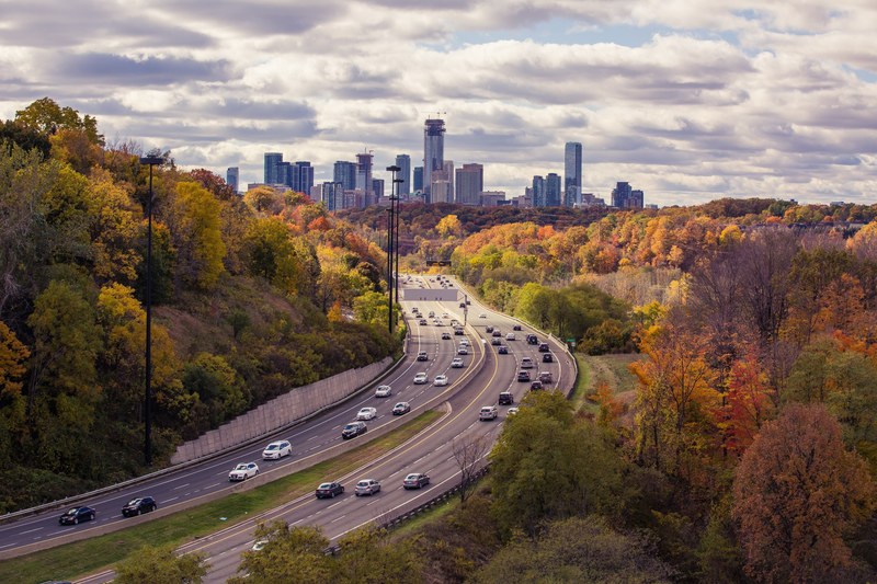 long shot of busy daytime highway traffic with autumnal trees at leaside bridge, busy daytime traffic at leaside bridge 4k