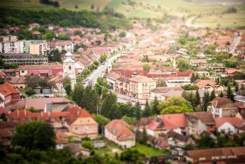small town with red roofed buildings in the countryside surrounded by fields of grass, small town red roofs 4k
