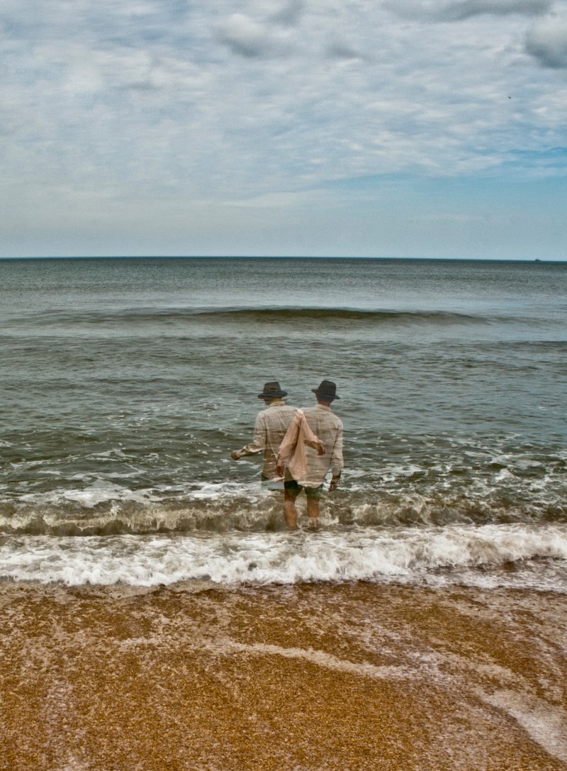 man in a shirt and a hat entering the ocean, man entering ocean 4k