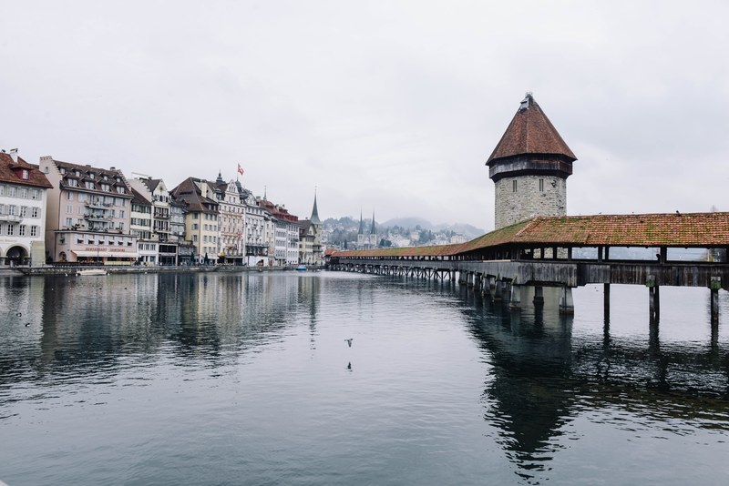 view of buildings and a bridge at the lakeside in lucerne on a foggy day, buildings on a lakeside in lucerne 4k