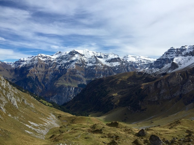 a view on the claridenhorn summit overlooking a rocky green valley, valley near claridenhorn 4k