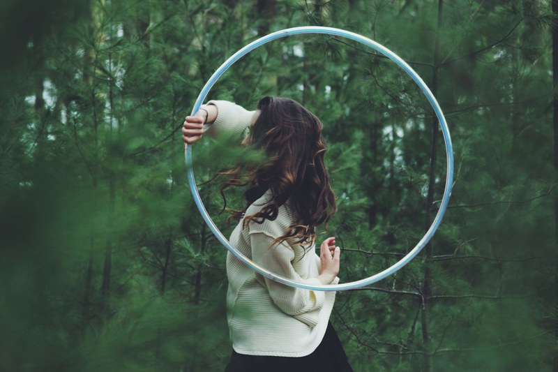 a woman with a hula hoop in a dense forest, hula hoop in green woods 4k