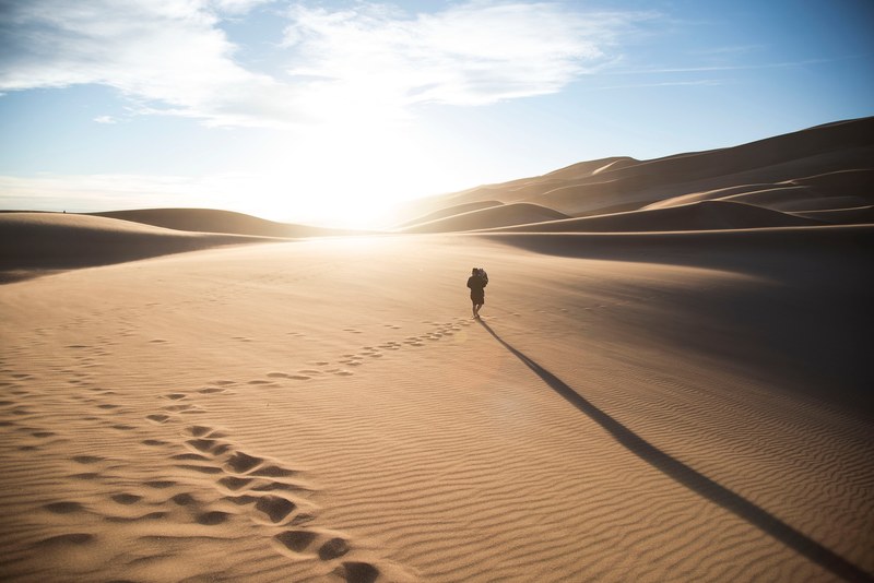 a person walking through the sand leaving footprints on the dunes at great sand dunes national park and preserve, footprints 4k