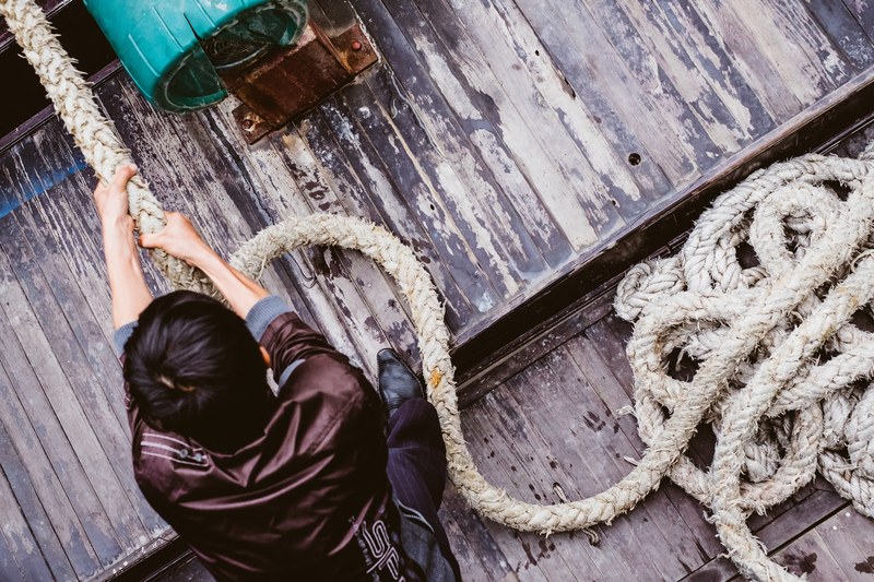 a man pulling on a rope on a dock in h long bay, h long bay dock 4k