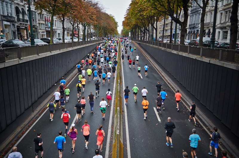 a large group of people running in a marathon in the middle of a street in brussels, brussels marathon runners 4k