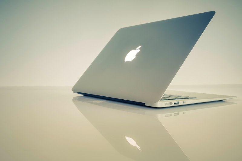 a half closed macbook on a reflective surface, macbook on glossy table 4k