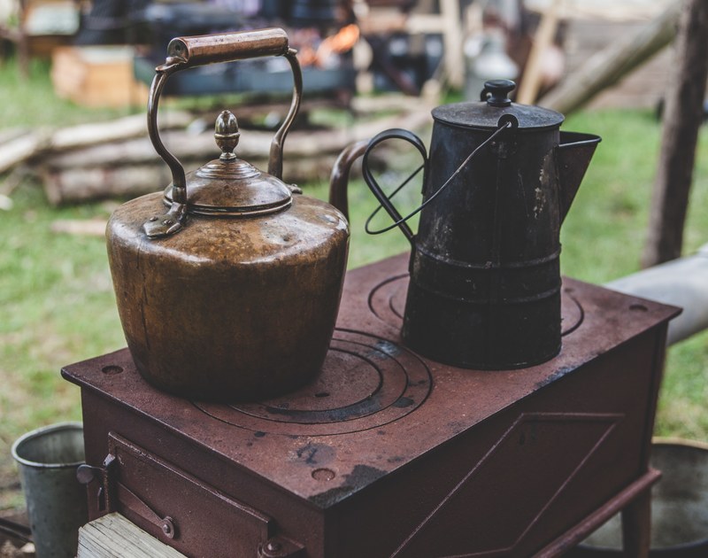 rustic kettles on top of an antique stove outdoors, rustic stovetop 4k