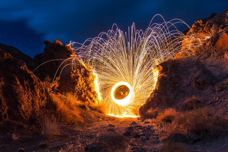 bright spiral firework at night in mountains on dusty landscape, spiral firework in mountains 4k