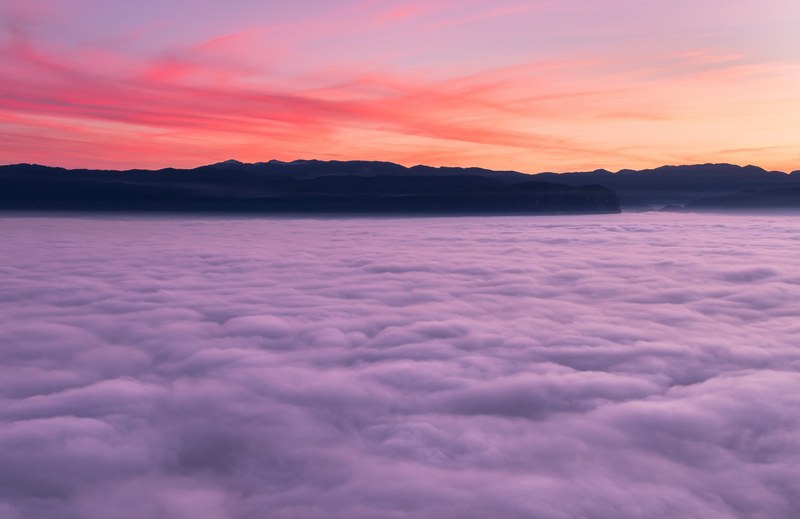 the pink and purple sky during sunrise or sunset over the clouds and mountains in ajdna, foggy sunset 4k