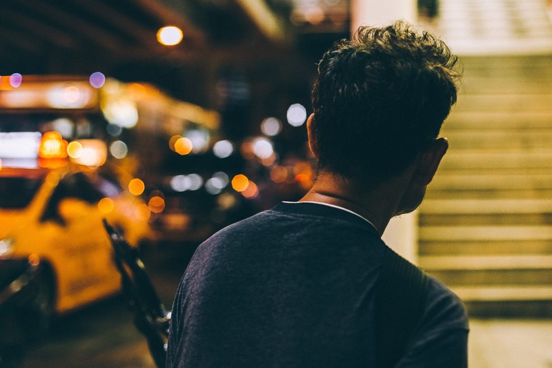 a person faces away from the camera toward stairs and traffic in bangkok, man facing stairs and traffic 4k