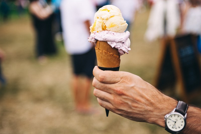 hand hold an ice cream cone with two scoops at a festival, festival food 4k