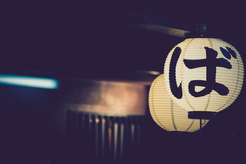 two illuminated japanese lanterns in a dark setting by a door, two japanese lanterns 4k