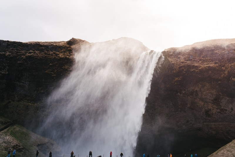 an impressive waterfall spraying water over a rocky face in iceland, frothy waterfall in iceland 4k