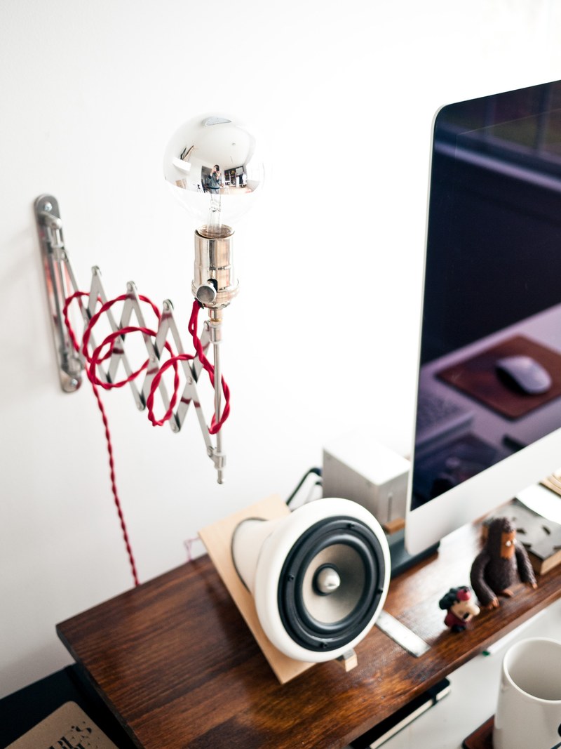 wall mounted extendable light behind a sophisticated computer set up, throw some light on the subject 4k