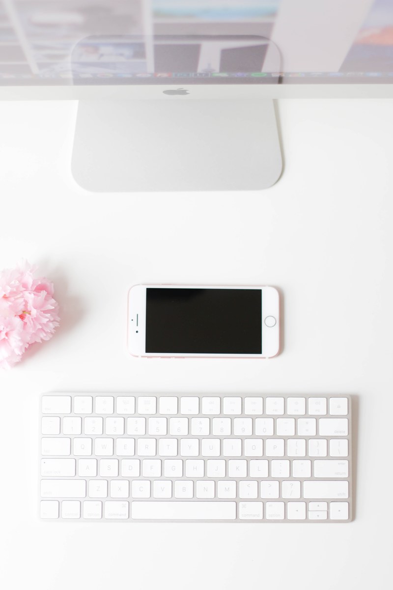 a flatlay image of a smartphone next to a mac monitor and keyboard, _her workspace 4k