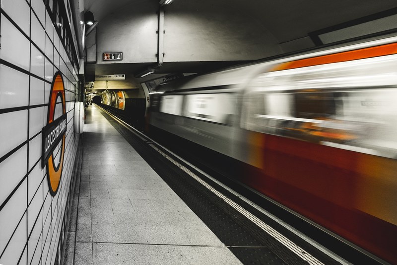 a blurry shot of a moving train from the platform in leicester square station, _fast transit 4k