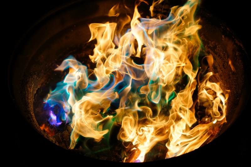 an orange fire with blue purple and green flames at night, rainbow flames 4k