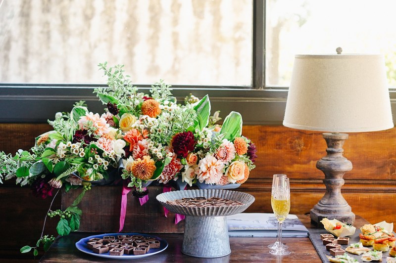 sweet treats and champagne next to an impressive arrangement of flowers on a table, dessert champagne and flowers 4k