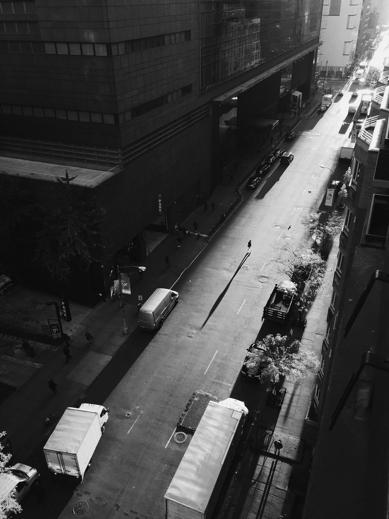 black and white drone shot of pedestrians walking on shadowed street in new york, black and white street 4k