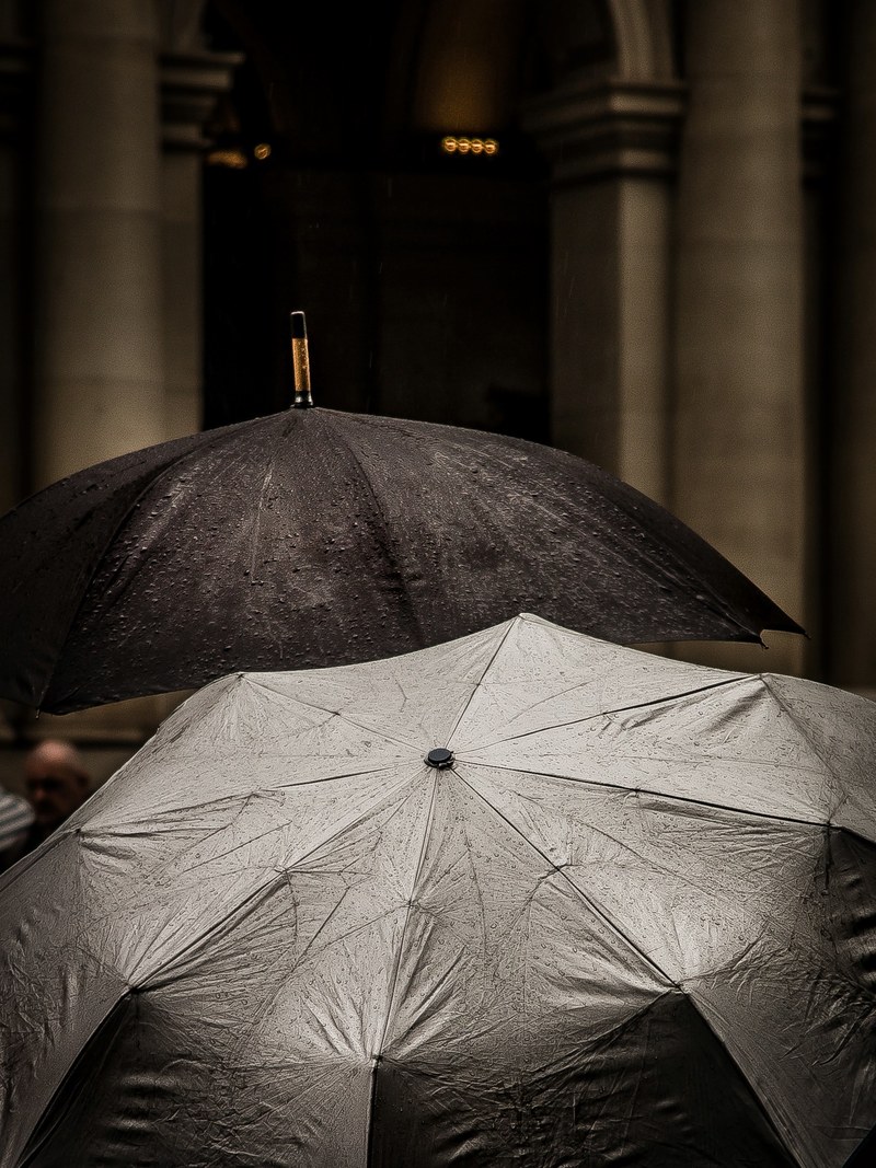 a black and a silver reflective umbrella during the rain on bourke street, bourke street umbrellas 4k