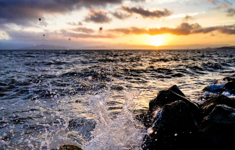 water sunset rock and wafe 4k
