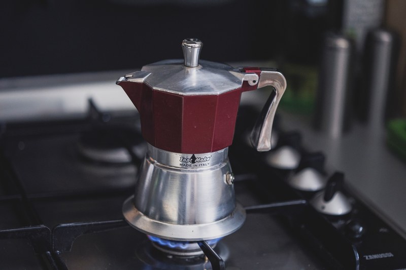 a small kettle on a stove burner, brewing coffee on a stove 4k