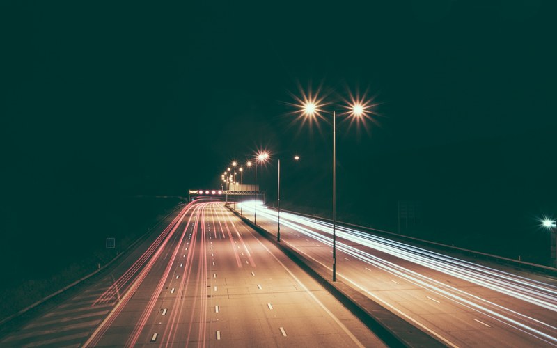 a long exposure shot with long light rails on a highway at night, highway light trains at night 4k