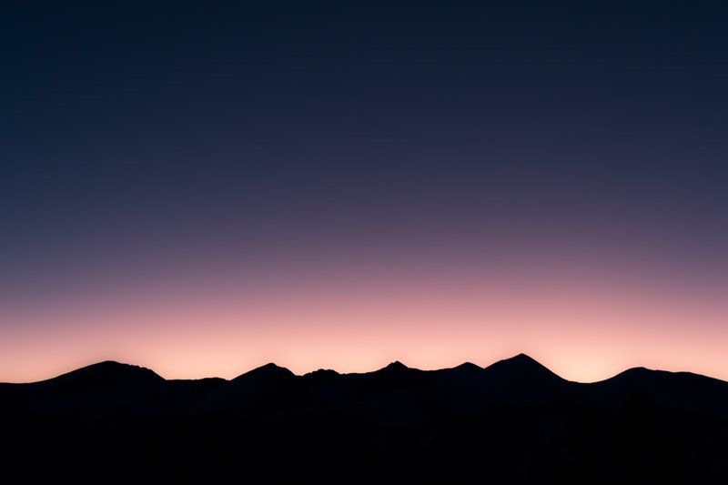 dark silhouettes of lofty mountaintops under a purple evening sky, mountains against purple sky 4k