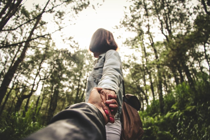 a couple holding hands walking through the forest together, forest couple 4k
