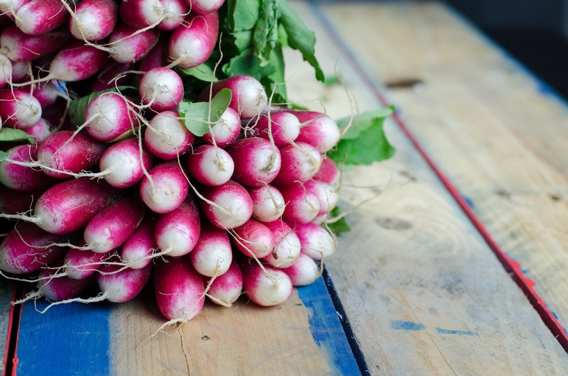 a large bunch of radishes on a wooden surface, fresh radishes 4k