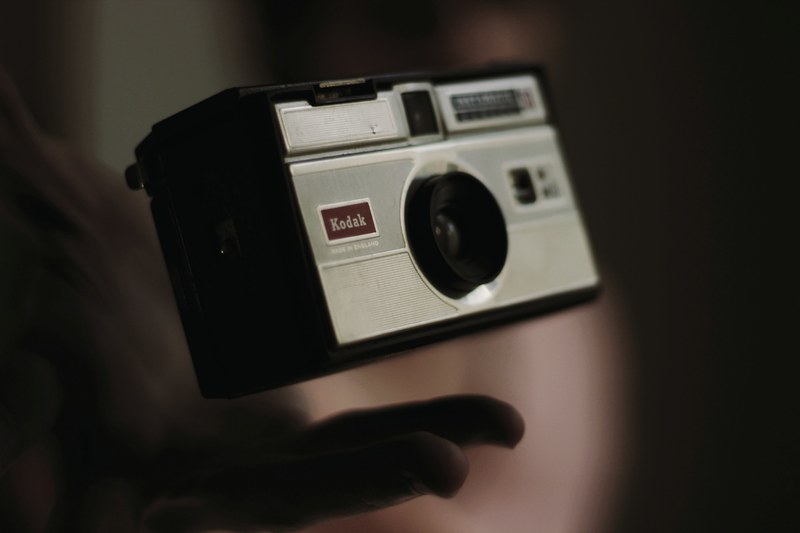 macro of a person throwing a vintage kodak camera slightly in the air, kodak vintage camera 4k