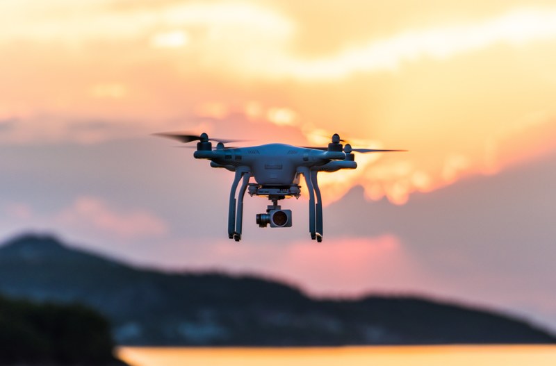 a drone flying over cariocas beach at sunset with a dusky mountain landscape in the background, drone flying at cariocas beach at sunset 4k