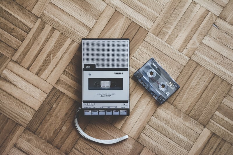 an old philips cassette player and tape laying on a wooden floor in italy, old but gold 4k