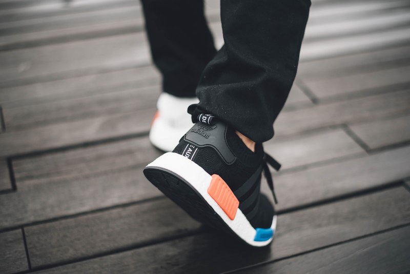 black and white sneakers with logos and black pants walking on wooden surface, black white sneakers logo 4k