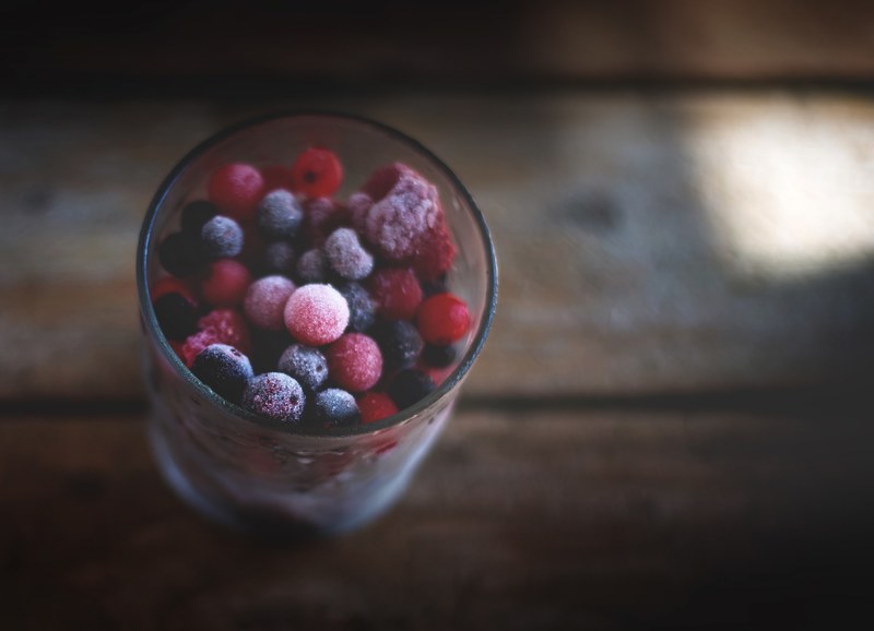 tall glass of frozen blueberries raspberries and assorted berries, frozen berries 4k