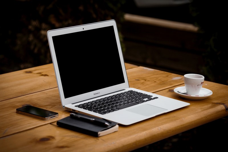 a macbook laptop on a desk with other things like iphone mug pen and a notebook, macbook laptop on a desk 4k