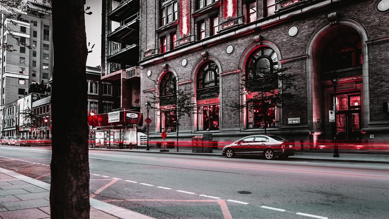 a classy shot of a city road in grey and red with subtle red light trails, red street light trails 4k