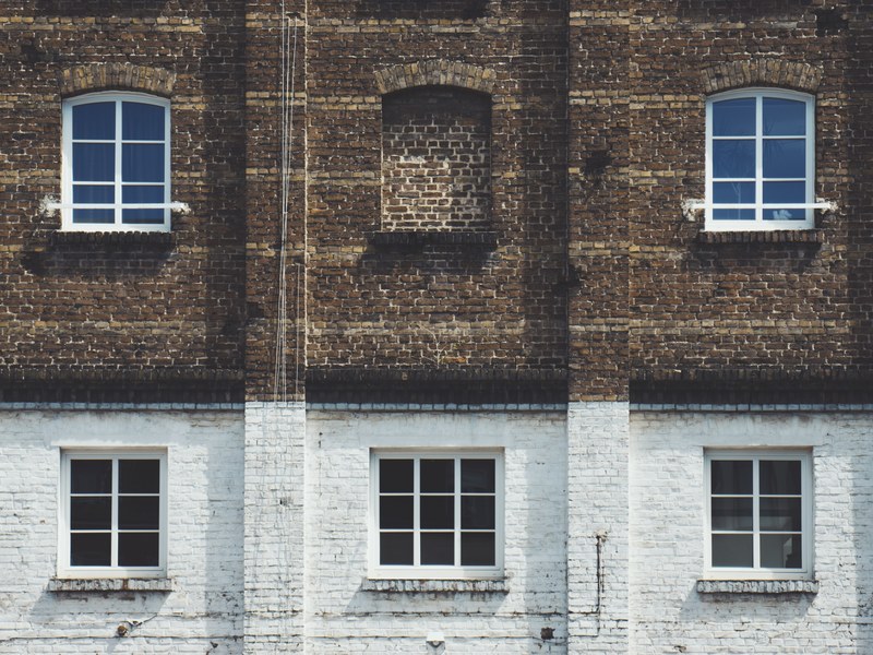 side view of a brown and white brick building with windows and cables along the bottom, brown and white building 4k