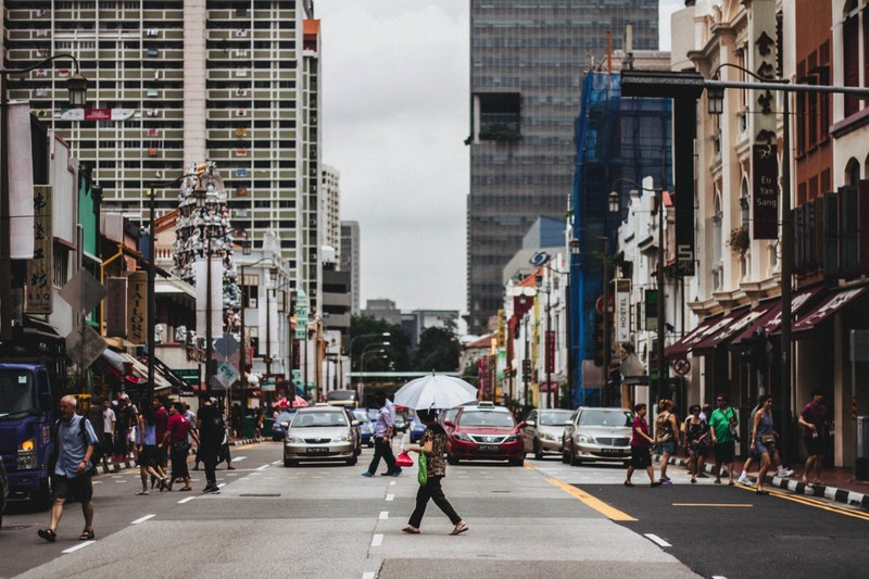 woman with the umbrella crossing the busy urban street in singapore, crossing 4k