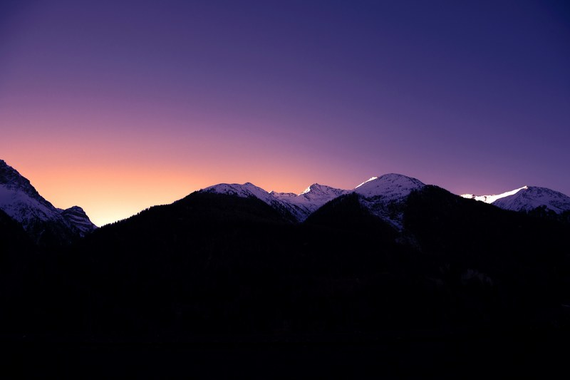 a dim shot of snow topped peaks under a purple hued sky during sunset, morning mood 4k