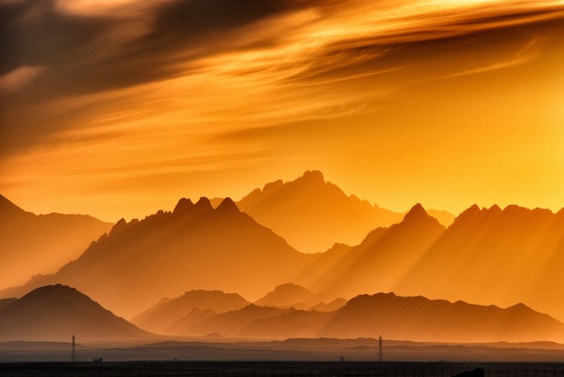 view across hurghada international airport toward hills that are covered in the orange glare from the sunrise or sunset, sunset in the mountains 4k
