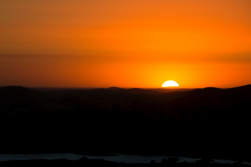 a dark orange sky as the sun sets with the horizon in silhouette at sky harbour road, _new horizons 4k