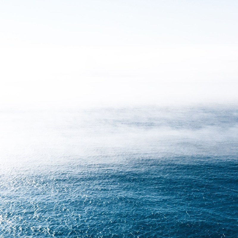 fog rolls over wavy blue waters in portugal, ocean mist in portugal 4k