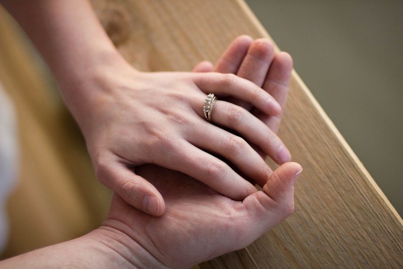 brides hand wearing wedding ring sits on grooms hand in chattanooga, groom holds brides hand 4k