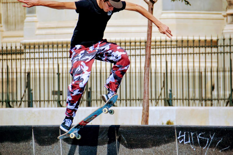 a person in a baseball cap and camouflage pants does a skateboard trick, person doing skateboard trick 4k