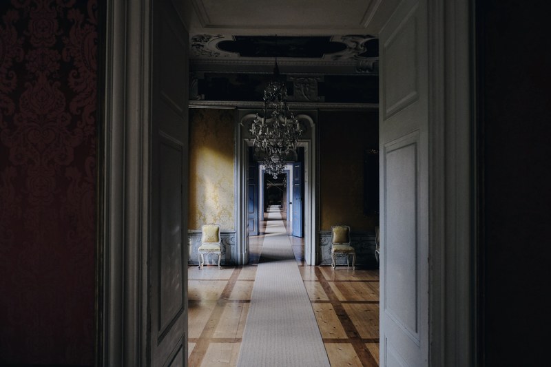 long hallway through many rooms with a classic style and chandelier in the first room, hallway with many rooms 4k