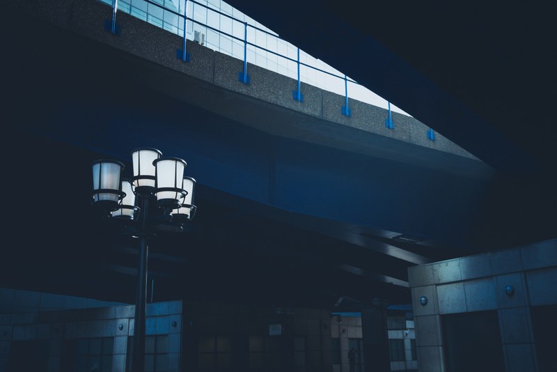 futuristic scene at canary wharf of lamppost in blue light on street surrounded by buildings, blue lampost canary wharf 4k