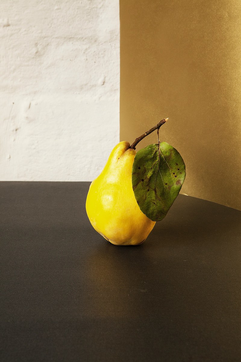 freshly picked juicy yellow pear with a leaf on a table, freshly picked pear 4k